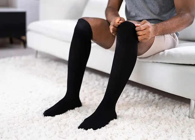 person putting on compression socks