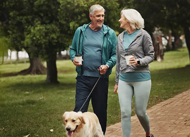 man and woman walking dog