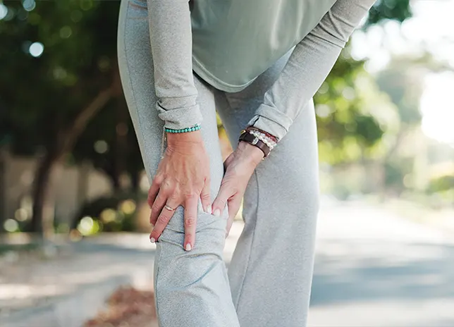 person holding knee in pain
